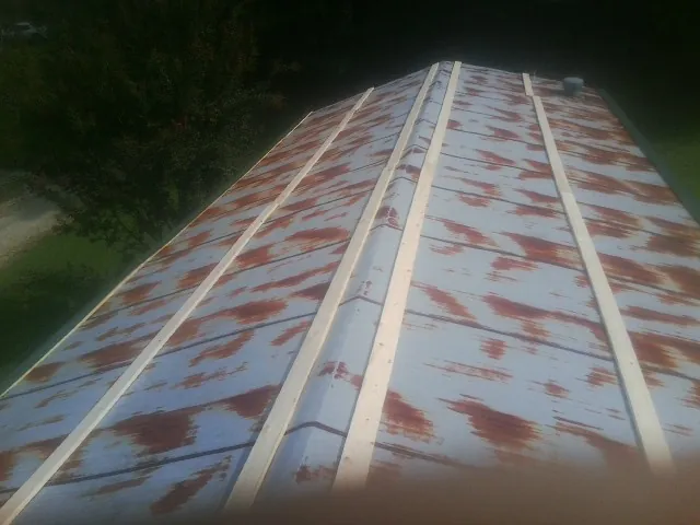 Rusted metal roof panels with new wood purlins before replacement — Storm Damage Roof Repair in Lampasas by Roofing Brothers